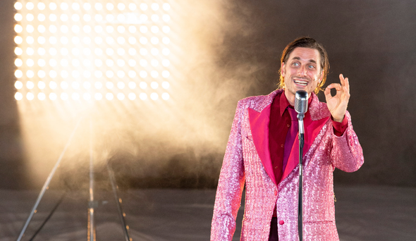 Foto di scena dello spettacolo dove si vede l'attore Luca Marinelli davanti a un microfono 